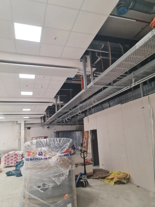 Ceiling void with cable trays above a new drywall wall – Deizisau
